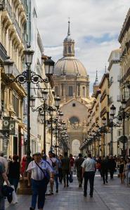 a group of people walking down a city street at Apartamento en el centro de zaragoza "EL RUBÍ DEL PILAR" in Zaragoza