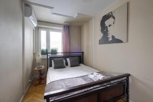 um quarto com uma cama com uma fotografia na parede em Jazz Residential Apart em Varsóvia
