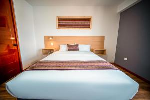 a bedroom with a large white bed in a room at Ayni Cusco Hotel in Cusco