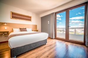 a bedroom with a large bed and a large window at Ayni Cusco Hotel in Cusco +89 photos
