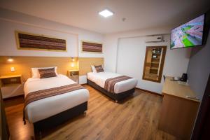 ein Hotelzimmer mit 2 Betten und einem Flachbild-TV in der Unterkunft Ayni Cusco Hotel in Cusco