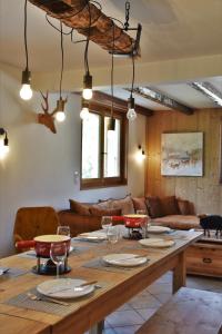 una sala da pranzo con tavolo in legno e bicchieri da vino di Chalet la Dransette a Châtel