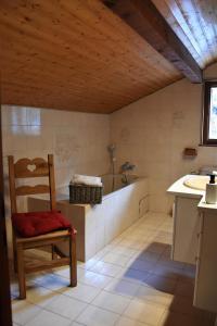 een badkamer met een stoel, een wastafel en een bad bij Chalet la Dransette in Châtel