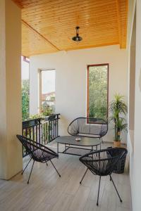 a patio with three chairs and a table on a balcony at Kera Rooms in Tʼelavi