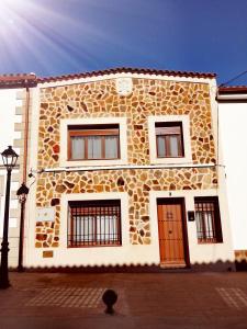 a large stone building with a red door at Vivienda Rural Ronda in Aldeaquemada
