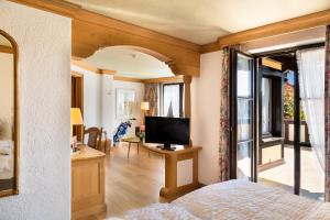 a bedroom with a bed and a tv and a window at Eurener Hof in Trier