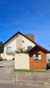 a brown and white house with a garage at Valentina Ramos Pousada - Joinville-SC in Joinville