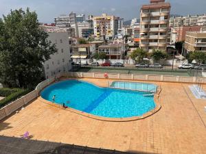 ein großes Schwimmbad mitten in einer Stadt in der Unterkunft Apartamento 1ª Línea de Playa - Con Piscina y Parking in Gandía
