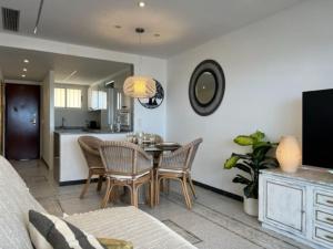 sala de estar con mesa y sillas y cocina en Apartamento 1ª Línea de Playa - Con Piscina y Parking, en Gandía