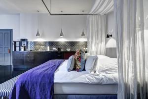 a bedroom with a large bed with a purple blanket at Gorki Apartments in Berlin