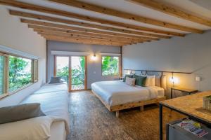 1 dormitorio con 2 camas y sofá en Hotel La Palma y El Tucán, en Zipacón