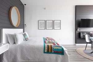 een slaapkamer met een bed, een spiegel en een stoel bij Cliffs Edge Retreat in Bauline East