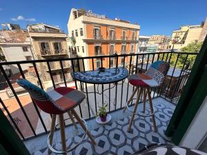 巴勒莫Elisir house的阳台上有两把椅子和一张桌子