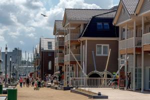 eine Gruppe von Häusern in einer Stadtstraße mit Menschen in der Unterkunft CBlue: Küstenzauber barrierefrei mit Balkon in Heiligenhafen