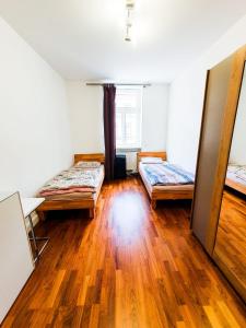 Habitación con 2 camas y suelo de madera. en VIP Wohnung Heidelberg, en Heidelberg