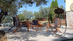 ein paar Holzstühle und eine Schaukel in der Unterkunft La Casa del Grillo in Viterbo