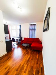 sala de estar con sofá rojo y mesa en VIP Wohnung Heidelberg, en Heidelberg