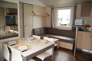 a dining room with a table and a couch at L'Odyssée in Aureilhan