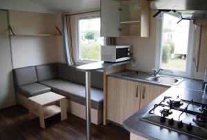 a small kitchen with a couch and a sink at L'Odyssée in Aureilhan