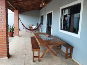 a wooden table and bench on a patio at Casa Temporada Cunha/SP - Gray House in Cunha