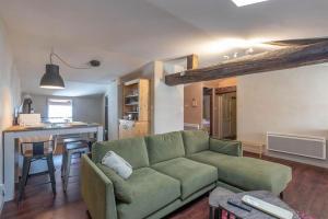 uma sala de estar com um sofá verde e uma cozinha em Cabana & Le Chaleureux - Centre-Ville em Cluny