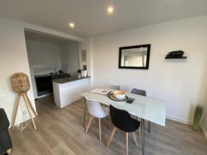 a dining room with a white table and chairs at Appartement Cholet les Halles coté jardin in Cholet