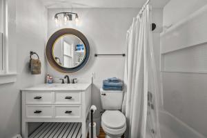 a bathroom with a toilet and a sink and a mirror at Cozy Condo Near Downtown! in Louisville
