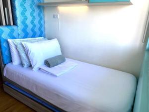 a small bed with two pillows on top of it at Big & Modern Condo with a Wide Balcony & Free Netflix in Manila