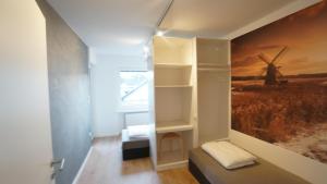 una habitación con una pared con una pintura de un molino de viento en ferienwohnung-senne Apartment Romeo, en Schloss Holte-Stukenbrock