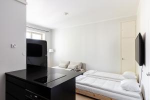 a white room with a black desk and a bed at Cozy apartment close to Helsinki Cathedral in Helsinki