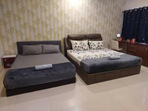 a bedroom with two beds and a ottoman at Home in Gelugor4R3B Dnaz Homestay@Sg. Dua in Gelugor