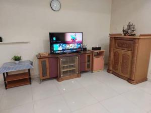 a living room with a tv and wooden furniture at Home in Gelugor4R3B Dnaz Homestay@Sg. Dua in Gelugor