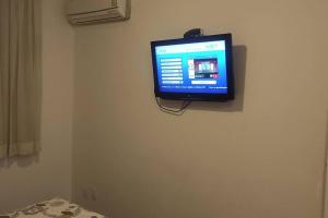 a television hanging on a wall in a room at Apart Hotel 48 in Mogi das Cruzes