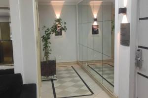 a room with a mirror and a potted plant at Apart Hotel 48 in Mogi das Cruzes