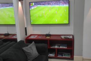 a living room with a tv with a soccer game on it at Apart Hotel 48 in Mogi das Cruzes