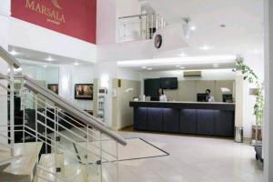 a lobby of a pharmacy with two people in the counter at Apart Hotel 48 in Mogi das Cruzes