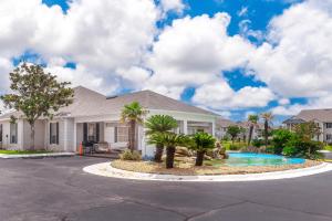 una casa con palme nel vialetto di Colony Club M8 - Pelican Perch a Gulf Shores