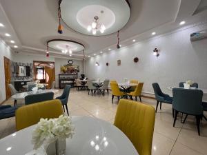 uma sala de jantar com mesas e cadeiras amarelas em MASSAGET HOTEL em Nukus