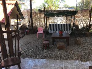 un patio trasero con un banco, una mesa y una silla en Casa en Cuchilla Alta, en Cuchilla Alta