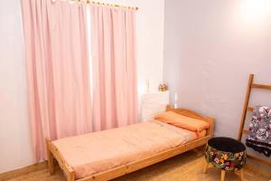 サンタ・テレシータにあるLa casita de la Costaのベッドと窓のある小さな寝室