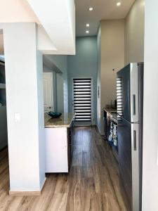 een keuken met een roestvrijstalen koelkast en houten vloeren bij Departamento Beto in Tijuana