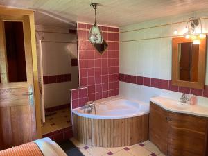 a large bathroom with a tub and a sink at Espace Famille Montmillon in Chamblay