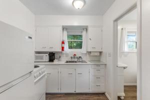 a white kitchen with white cabinets and a sink at Cute as a Clam Cottage Room 2 in Ocean Park