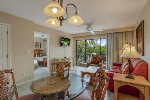 a living room with a glass table and a couch at Fabulous Park Shore Condo in Naples