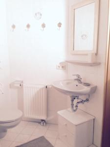 a white bathroom with a sink and a toilet at Ferienwohnung Himmel in Oberstaufen