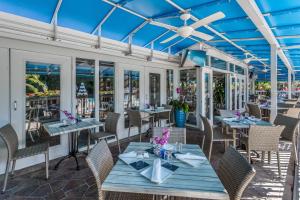 a restaurant with blue ceilings and tables and chairs at Fabulous Park Shore Condo in Naples