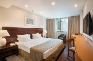 una camera d'albergo con letto, scrivania e TV di Windsor Plaza Copacabana a Rio de Janeiro
