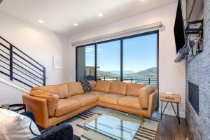 a living room with a couch and a large window at On Top of the Mountains - Full Townhome in Keetley