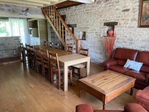 ein Wohnzimmer mit einem Tisch, Stühlen und einer Treppe in der Unterkunft Espace Famille Montmillon in Chamblay