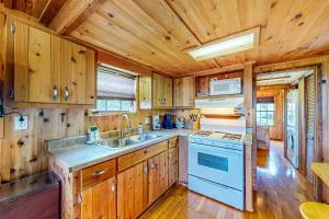 cocina con armarios de madera, fregadero y fogones en Seneca Lake Serenity, en Hector
